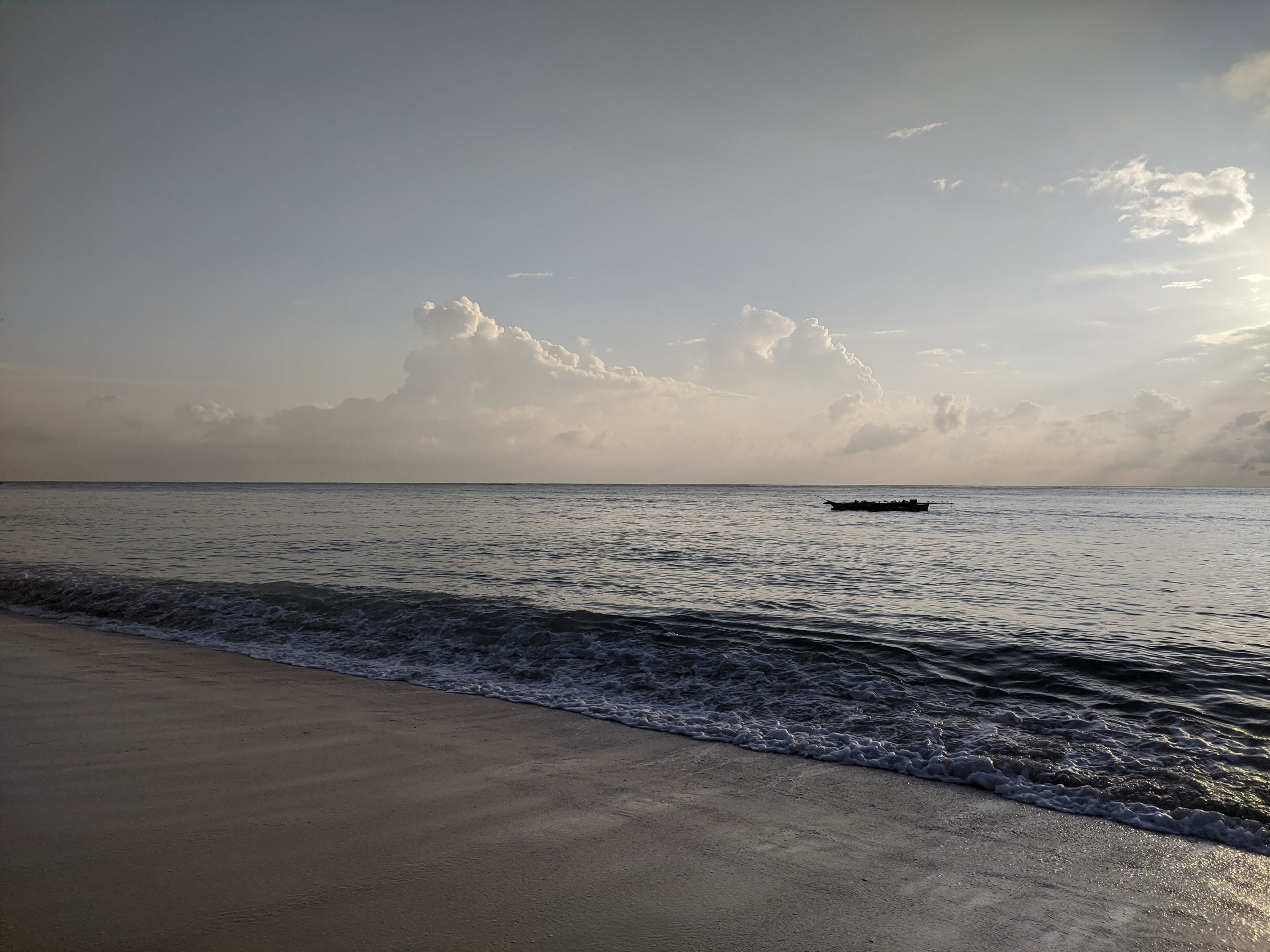 A ngalawa fishing boat on the horizon at dawn, Diani Beach